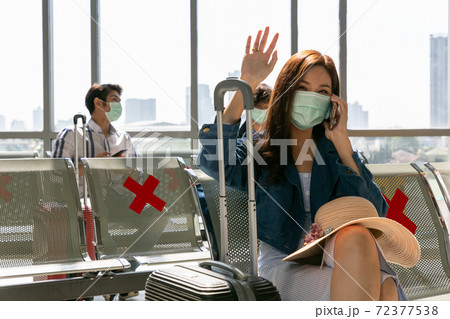 Girl waves her hand on arrival. woman sitting in hall along the window out of gate saying hi to her friends cheerful. 72377538