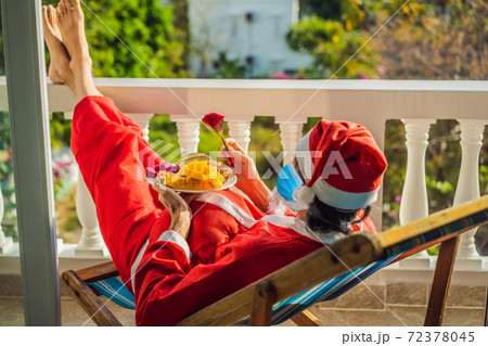 cheerful santa man in a medical mask hold exotic fruit. healthy gift. christmas during coronavirus COVID 19. bearded man healthy eating. merry christmas. happy new year. xmas gifts and presents 72378045