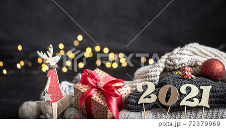 New year's composition with wooden new years number and sweaters on a dark background. 72379969