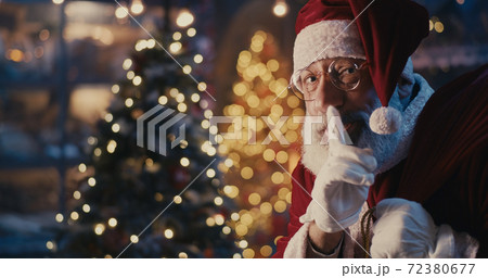 Happy Santa Claus walking quietly near Christmas tree 72380677