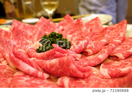 皿に盛りつけられた牛しゃぶしゃぶ肉と人影 皿に盛りつけられた牛しゃぶしゃぶ肉と人影 72380688