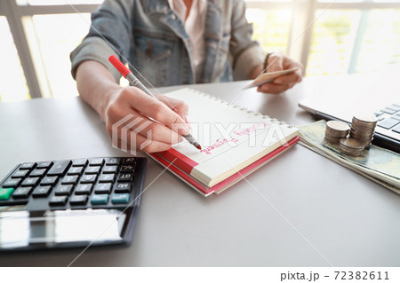 businesswoman writing down monthly payment list on notebook with computer and credit card businesswoman writing down monthly payment list on notebook with computer and credit card 72382611