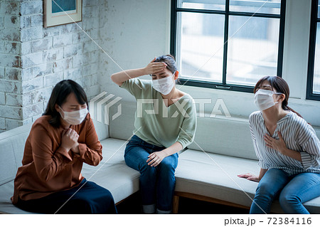 体調不良を訴える女性 72384116
