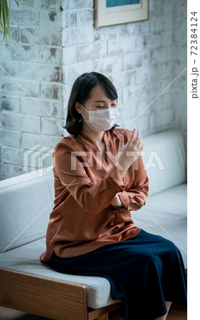 手がしびれる症状　若い女性 72384124