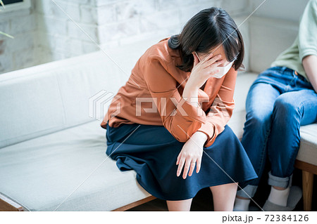 体調不良を訴える女性 72384126