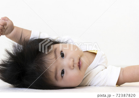 仰向けでカメラ目線の赤ちゃん(0歳、生後5か月、女の子) 仰向けでカメラ目線の赤ちゃん(0歳、生後5か月、女の子) 72387820