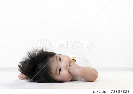 指を舐めるの赤ちゃん 0歳 生後5か月 女の子 の写真素材