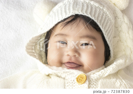 白いセーターとフードを着た赤ちゃんの顔(0歳、生後5か月、女の子) 72387830