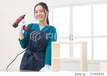 電動ドリルを片手に作品の完成を喜ぶDIY女子 72389691
