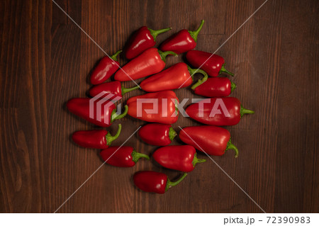 Top view. Stack of red pepper laid out on the wooden table. Large amount of red chilli peppers or capsicum Top view. Stack of red pepper laid out on the wooden table. Large amount of red chilli peppers or capsicum 72390983