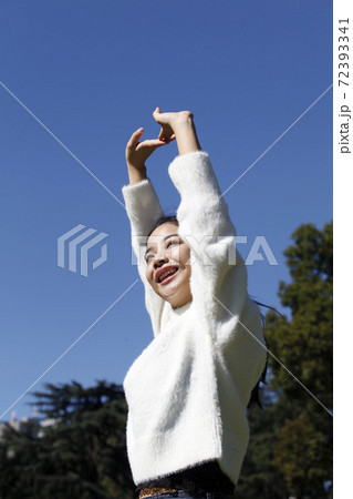 背伸びする若い可愛い女性の写真素材