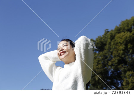 気持ち良さそうな若い可愛い女性と青空の写真素材