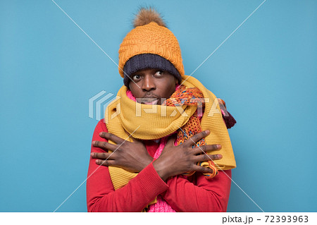 African american mature man in yellow scarf and hat freezing in warm clothing. African american mature man in yellow scarf and hat freezing in warm clothing. 72393963