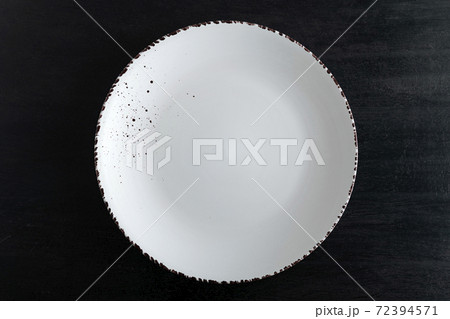 White designer plate on black background top view. Empty plate White designer plate on black background top view. Empty plate 72394571