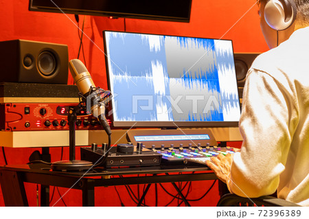 professional sound engineer recording, editing, mixing voice over waveform on computer in post production studio 72396389