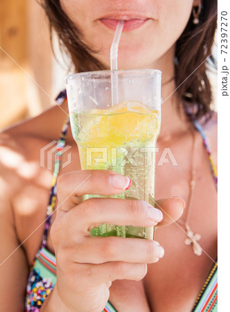 A glass of mojito with lemon and ice in the hands of women 72397270