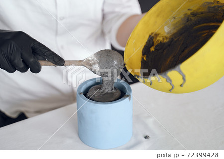 Man in a white shirt works with a cement Man in a white shirt works with a cement 72399428