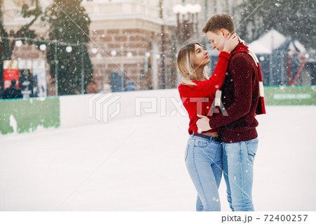 Cute and loving couplein a red sweaters in a winter city Cute and loving couplein a red sweaters in a winter city 72400257