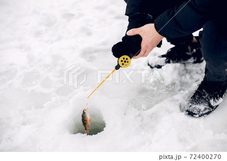 Handsome man on a winter fishing 72400270
