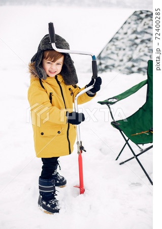 Cute little boy sitting on a winter fishing Cute little boy sitting on a winter fishing 72400285
