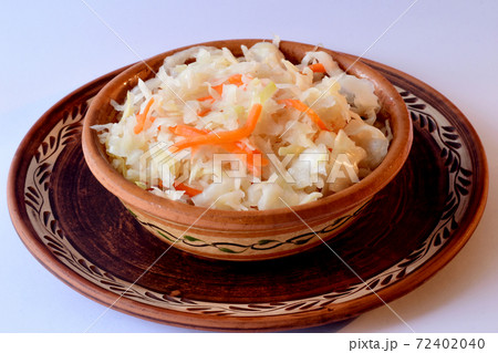 Sauerkraut with carrots in a clay plate on the table. 72402040