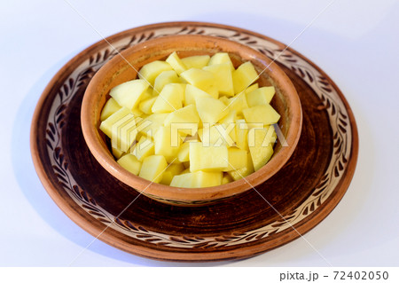 Finely chopped peeled potato tubers lie in a plate on white 72402050