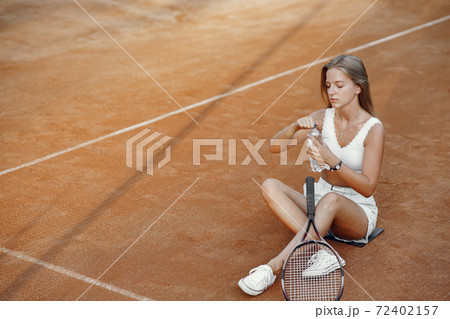Stylish woman in a summer tennis court 72402157