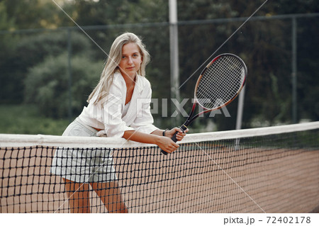Stylish woman in a summer tennis court Stylish woman in a summer tennis court 72402178