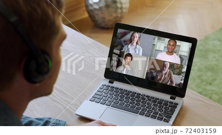 Rear view of men talking via video link with a variety of multiracial colleagues at an online briefing, a man at a group conference with colleagues on a laptop at home Rear view of men talking via video link with a variety of multiracial colleagues at an online briefing, a man at a group conference with colleagues on a laptop at home 72403159
