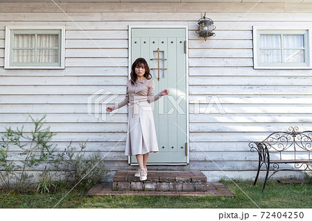 洋館の入り口のドアの前に立つ若い女性 72404250