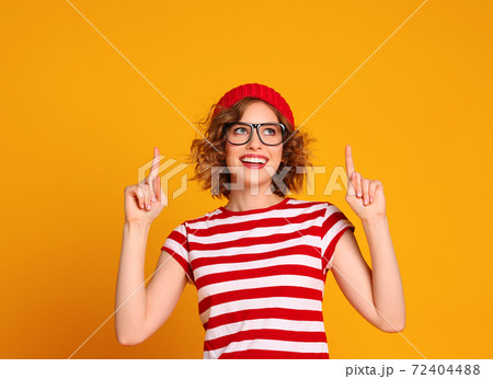 Cheerful stylish woman pointing up. Cheerful stylish woman pointing up. 72404488