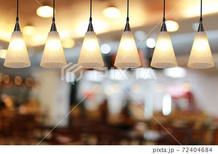 Modern lamp hanging from the ceiling of the restaurant. 72404684