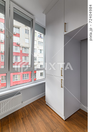 Empty heated penthouse living room with floor to ceiling windows 72404984