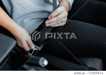 MURES, ROMANIA - OCTOBER 21, 2020, interior view of brand new Hyundai Tucson 2020. Young female driver using seat belt in the car before traveling 72405611