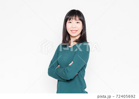 白背景の前で腕を組んでいる笑顔の女性 白背景の前で腕を組んでいる笑顔の女性 72405692