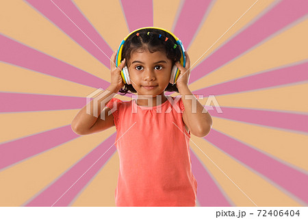Music, childhood and technology concept.Child with headphones over geometric background Music, childhood and technology concept.Child with headphones over geometric background 72406404