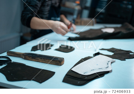 man shaping leather for shoe with knife on factory man shaping leather for shoe with knife on factory 72406933
