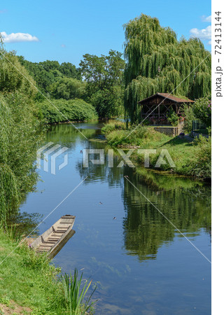 Boat on the river Ill near a village in the Alsace plain in France. Boat on the river Ill near a village in the Alsace plain in France. 72413144