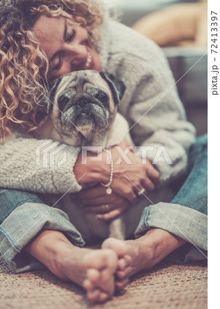 Love and friendship concept with happy defocused caucasian adult woman hug her lovely old dog pug - animal therapy and best friend together forever 72413397