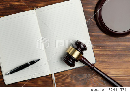 Judge hammer with a notebook on a wooden background Judge hammer with a notebook on a wooden background 72414571