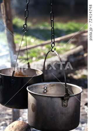 Two sooty old cauldrons on campfire at forest 72414748
