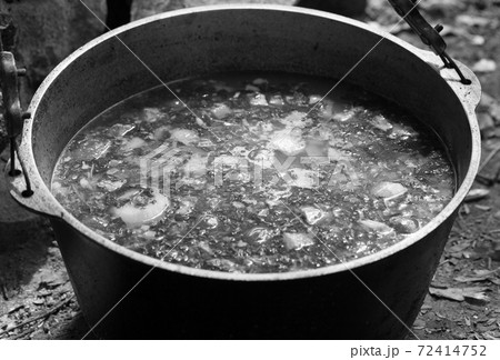Freshly cooked hot soup in sooty cauldron on camp fire Freshly cooked hot soup in sooty cauldron on camp fire 72414752