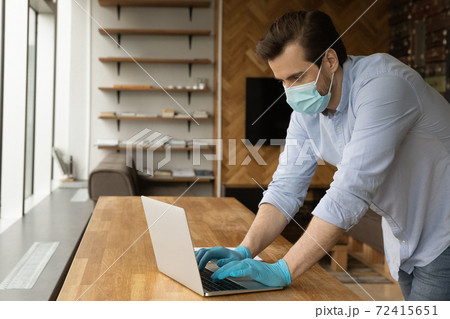 Caucasian man in medical gear work on laptop Caucasian man in medical gear work on laptop 72415651