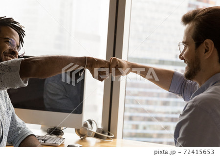 Happy multiethnic male friends give fist bump 72415653