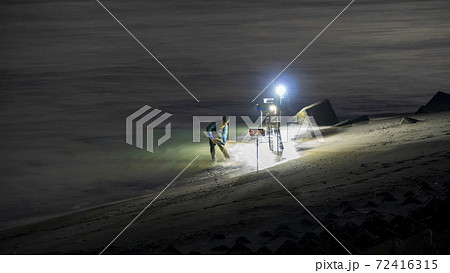 静岡県磐田市の天竜川河口で漁師が照明を頼りに波打ち際を手網ですくうシラスウナギ漁(ニホンウナギの稚魚 静岡県磐田市の天竜川河口で漁師が照明を頼りに波打ち際を手網ですくうシラスウナギ漁(ニホンウナギの稚魚 72416315
