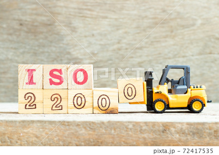 Toy forklift hold letter block 0 to complete word iso 22000 on wood background Toy forklift hold letter block 0 to complete word iso 22000 on wood background 72417535