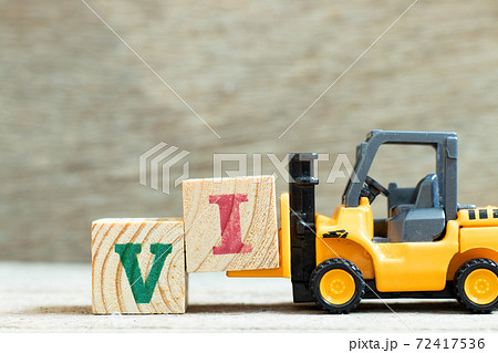 Toy forklift hold letter block to complete word VI (abbreviation for value investor) on wood background Toy forklift hold letter block to complete word VI (abbreviation for value investor) on wood background 72417536
