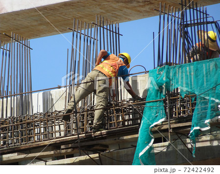 MALACCA, MALAYSIA -MARCH 2, 2020: Construction workers working at height at the construction site. They are supplied with harnesses and other safety equipment to prevent them from having an accident. 72422492