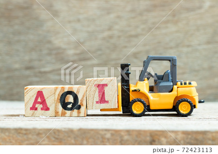 Toy forklift hold letter block I to complete word AQI (Air quality index)on wood background Toy forklift hold letter block I to complete word AQI (Air quality index)on wood background 72423113
