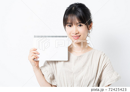 スケッチブックを持つ若い女性 72425423
